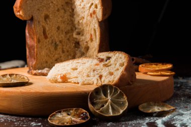 Koyu arkaplanda Noel pastası ve Noel süslemeleri. Aslen Milan 'dan gelen İtalyan ekmeği Noel için hazırlanır ve beğenilir..