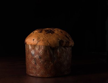 Koyu ahşap arkaplanda izole edilmiş çikolata panettone, metin için boşluk.