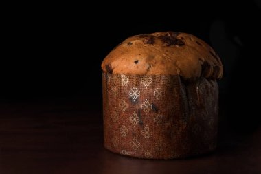 Koyu ahşap arkaplanda izole edilmiş çikolata panettone, metin için boşluk.
