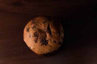 Koyu ahşap arka planda izole edilmiş çikolatalı panettone, metin için boşluk. Düz Yatay Görünüm