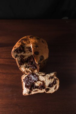 Koyu ahşap arka planda izole edilmiş çikolatalı panettone. Noel için geleneksel İtalyan tatlısı.