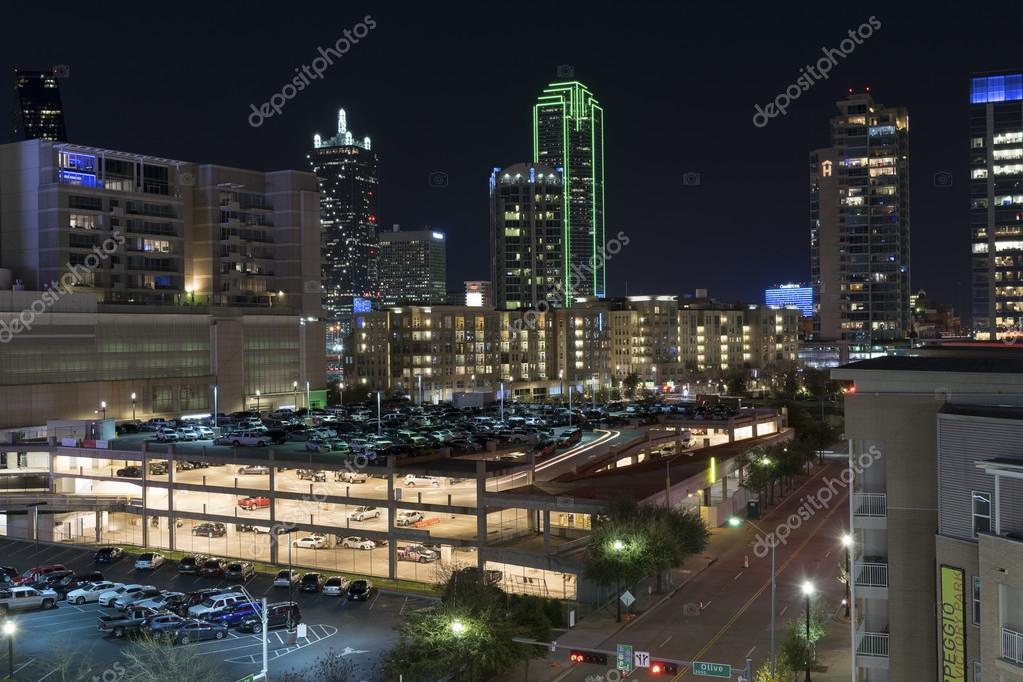 Фотообои Lights of the Dallas skyline beyond a lit up parking garage