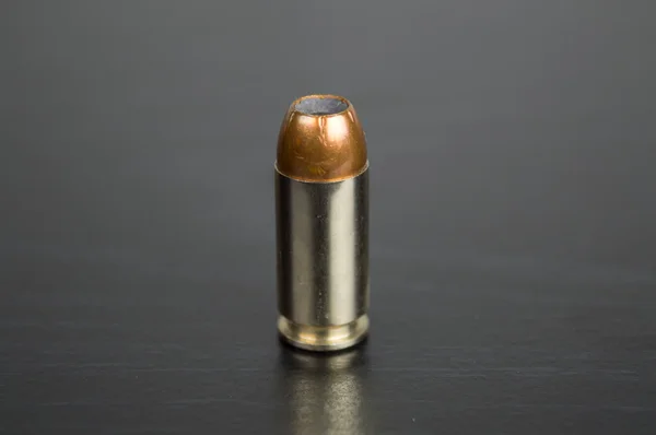 Single bullet for a gun on a black table Stock Photo