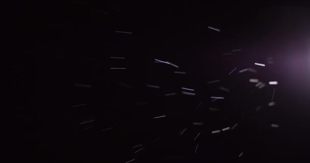 Regen fällt um das Licht mit dunkelschwarzem Hintergrund. Aufnahme mit 6K ROT Kamera. — Stockvideo