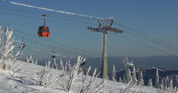 Skihütten in einem Skigebiet in den Bergen. Die Bewegung der Skilifte in einem verschneiten Winterberg. Scheregesch, Russland. — Stockvideo