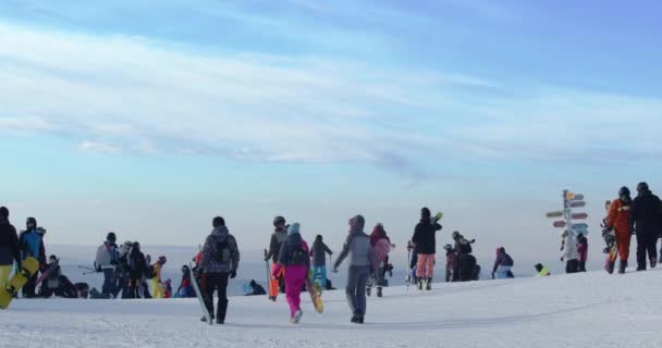 Толпы людей приходят на снежный склон горнолыжного курорта. Зимние каникулы в Сибири. Шерегеш, Россия. — стоковое видео