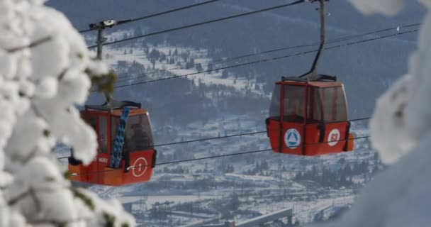 Skihütten in einem Skigebiet in den Bergen. Die Bewegung der Skilifte in einem verschneiten Winterberg. Scheregesch, Russland. — Stockvideo