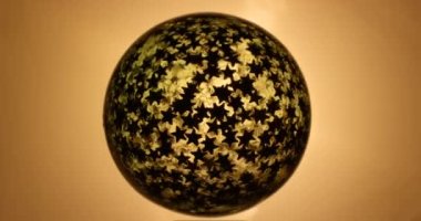 Yıldız deseni dönen soyut sarı küre.