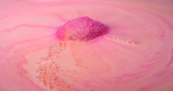 Bombe de bain rose colorée se dissout dans une eau chaude avec mousse et bulles — Video