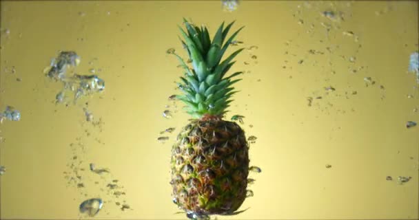 Ananas frais juteux tournant sous l'eau avec des bulles d'air montant. Tournage au ralenti filmé avec caméra ROUGE. — Video