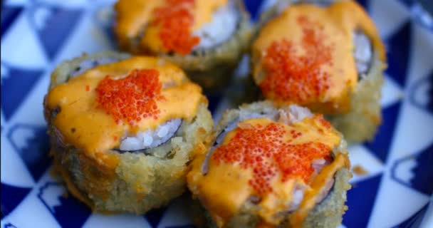 Vue rapprochée des baguettes japonaises qui prennent une partie du rouleau de sushi. Filmé avec une caméra rouge. — Video