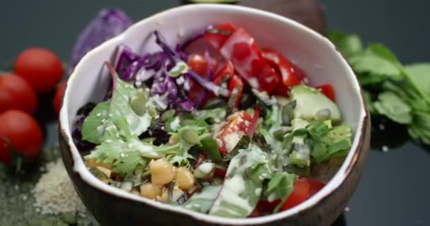 Ciotola Vegan poke con ceci, avocado, pomodorini, peperone, cavolo rosso, alcuni verdi, semi e salsa di anacardi. Vista a rotazione ravvicinata. — Video Stock