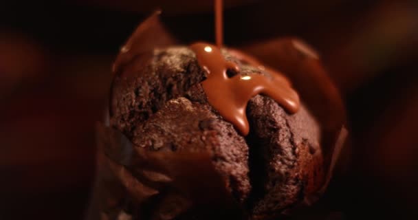 Mléčná čokoládová omáčka nalévá na muffinový dort zblízka. Natočeno ve zpomaleném filmu s RED kamerou. — Stock video
