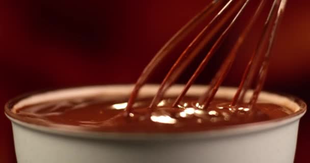 Mixing melted milk chocolate wit a corolla. Preparing chocolate sauce for dessert, fondue. — Stock Video