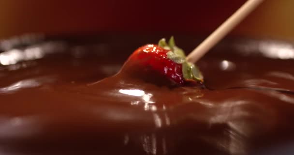 Verse rode aardbei in een warme melkchocolade gedaan. Chocolade fondue. — Stockvideo