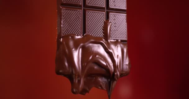 Chocoladereep met gesmolten chocolade die in slow motion stroomt. Close-up weergave gefilmd met RED camera. — Stockvideo