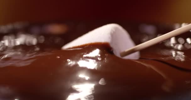 ゆっくりとした動きでダークチョコレートに浸かるマシュマロ。REDカメラで撮影されたクローズアップビュー. — ストック動画