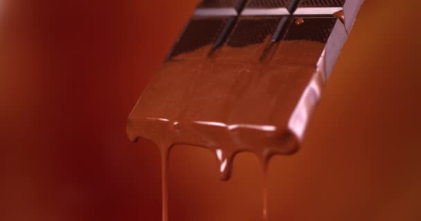Chocoladereep met gesmolten chocolade die in slow motion stroomt. Close-up weergave gefilmd met RED camera. — Stockvideo
