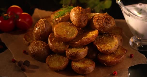 Forno assado Batatas com ervas, tomates frescos e molho de alho girando contra fundo escuro. Filmado em câmera lenta com câmera RED. — Vídeo de Stock