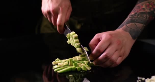 Chef Hände schneiden rohe Avocado in kleine Stücke. Gesundes Essen. Aufgenommen in Zeitlupe mit ROTER Kamera. — Stockvideo