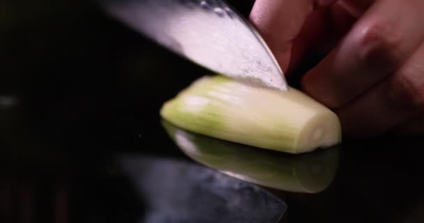 Mužské ruce kuchaře krájejí bílou cibuli v kuchyni na černém zrcadle. Zavřít záběr na RED kameru.