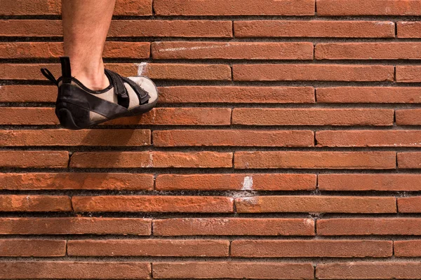 Climbing  a red brick wall — Stock Photo, Image