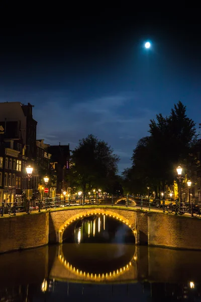 Amsterdam kanalları ile ay gece üzerinde köprüler