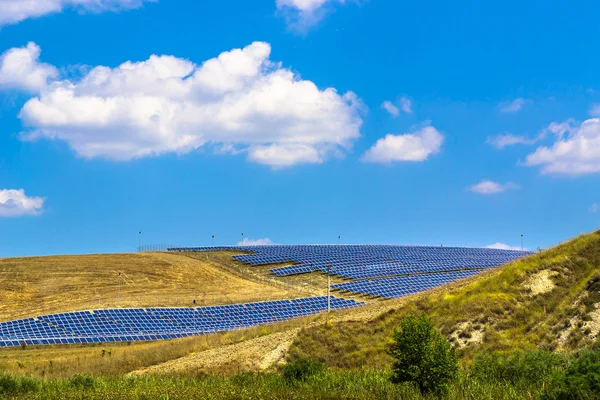 Solpaneler i ett kuperat landskap — Stockfoto