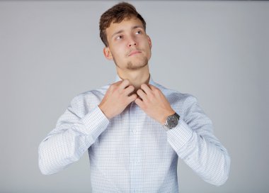 Genç yakışıklı işadamı Beyaz tişörtlü beyaz yakasını düzeltiyor.