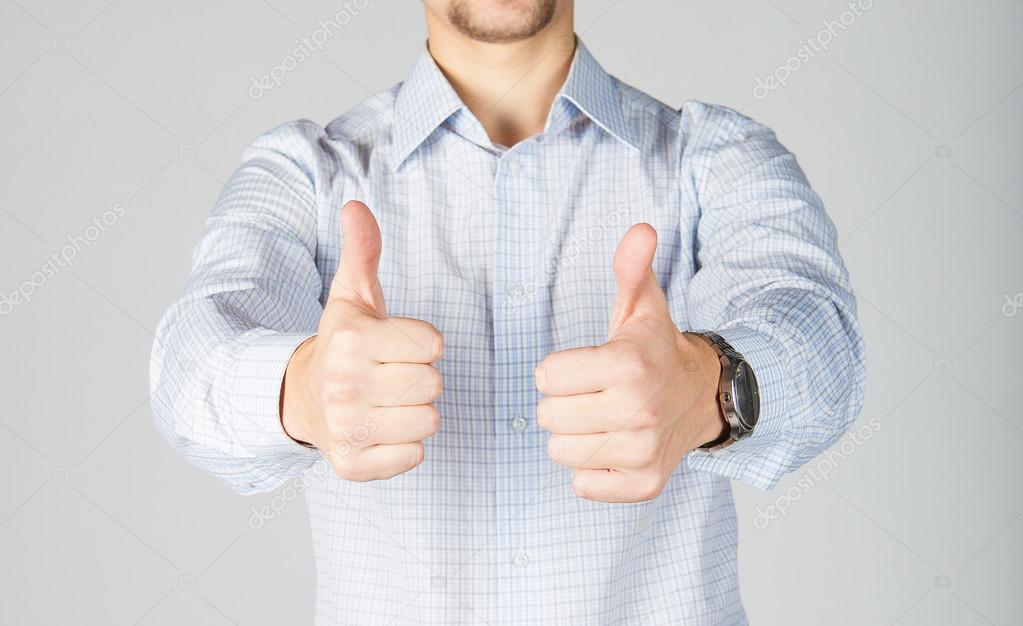 Young business man in white skirt gives thumbs up.