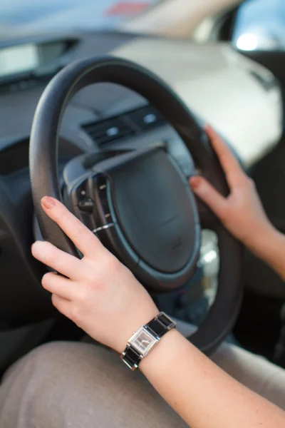 Women's hands on the wheel of a car — Stock Photo, Image