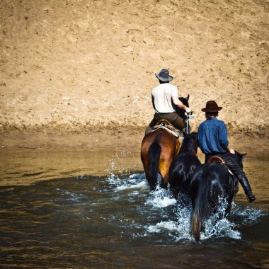 İki bisikletçi sırtında. Nehir geçiş