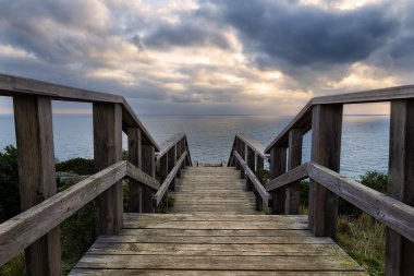 Merdiven aşağı kıyı günbatımında lider