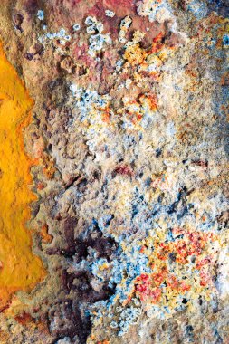 Endülüs İspanya 'nın Rio Tinto nehrinin kıyısında soyut dokular ve oluşumlar. Suda kırmızı ve turuncu, demir ve diğer minerallerin gölgeleri.