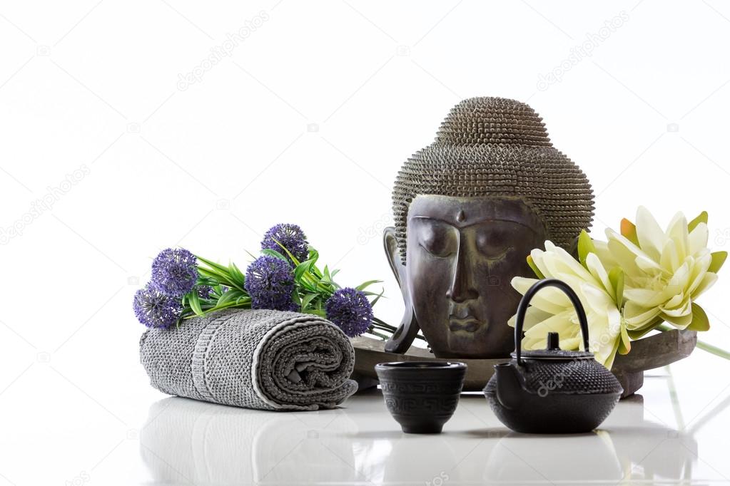 Buddha head on a white background, towel, teapot and lotus