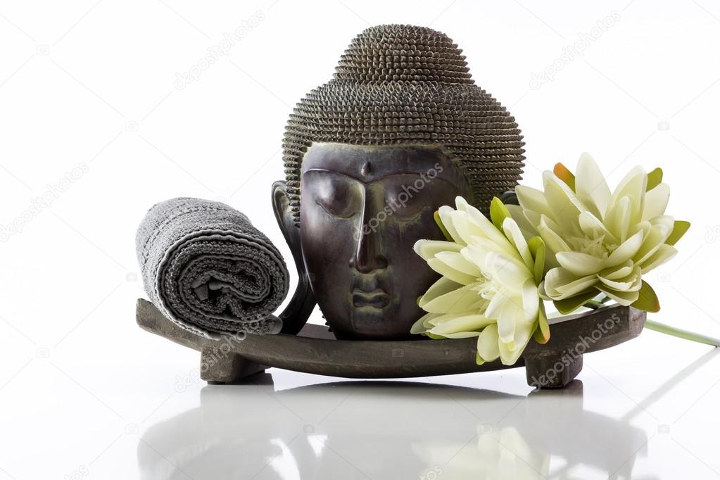 Buddha head on a white background, towel and lotus