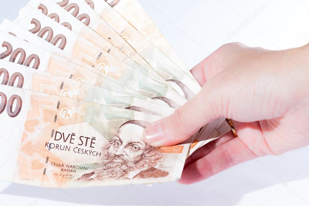 Female hand holding czech banknotes