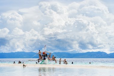 Moalboal. Cebu. Filipinler. -24 Haziran 2016: Asya insanlar getting eğlenceli ve geri kalan turistler ile bulutlu gökyüzü altında tropikal denizde teknede