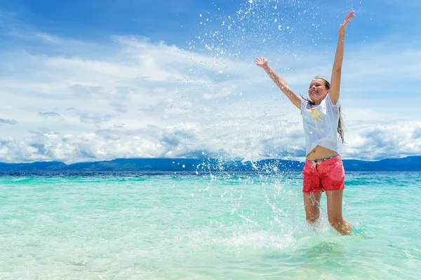 Jeune fille magnifique jouant avec de l'eau turquoise à l'île tropicale sous le ciel bleu — Photo