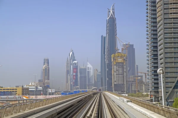 DUBAI, EMIRADOS ARAB UNIDOS - 16 DE JUNHO DE 2015: Skycrapers no centro moderno de Dubai com ferrovias de metrô, Dubai, Emirados Árabes Unidos — Fotografia de Stock