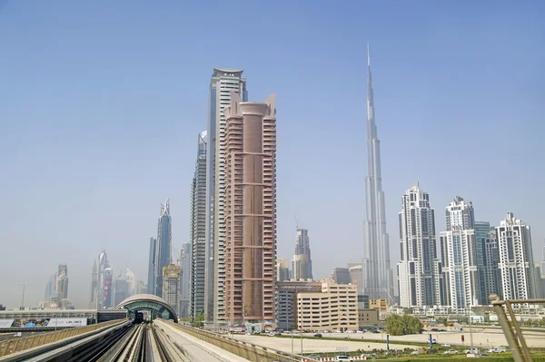 Dubai, vereinigte arabische Emirate - 16 juni 2015: hochhäuser im modernen zentrum dubais mit metrobahnen, dubai, vereinigte arabische emirate — Stockfoto