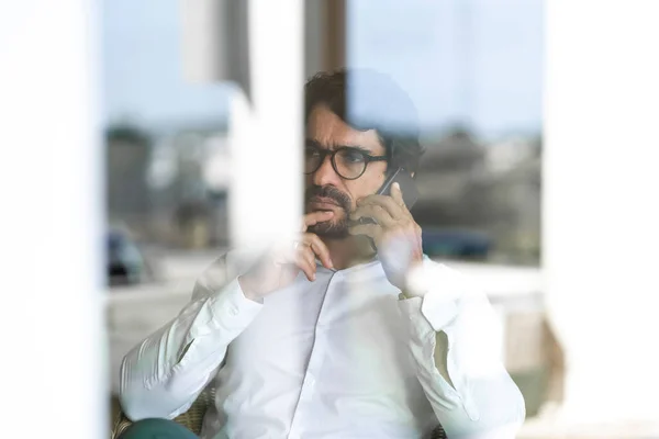Ένας Άντρας Γυαλιά Κάνει Ένα Τηλεφώνημα Κάθεται Και Κοιτάει Από — Φωτογραφία Αρχείου