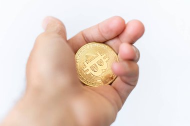 Bitcoin. Elinde BTC sembolü olan altın sikke. Kripto para birimi konsepti gibi sanal varlıklara yatırım yapan kişi