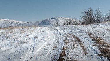 Kış yolu, Olkhon adasında ender bir ormanla kaplı tepelerle kaplı bozkırın içinden geçer..