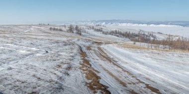 Kış yolu, Olkhon adasında ender bir ormanla kaplı tepelerle kaplı bozkırın içinden geçer..