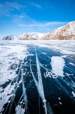 Baykal Gölü 'nün karanlık, uçsuz bucaksız buzunda ufkun ötesine uzanan uzun, kıvrımlı çatlaklar.