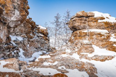 Sarı bir kaya, kar beyazı Tazheran bozkırının ortasında, tepenin zirvesini taçlandırır..