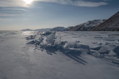 Alçak akşam güneşi Baykal Gölü kıyısındaki kaotik hummozları aydınlatıyor..