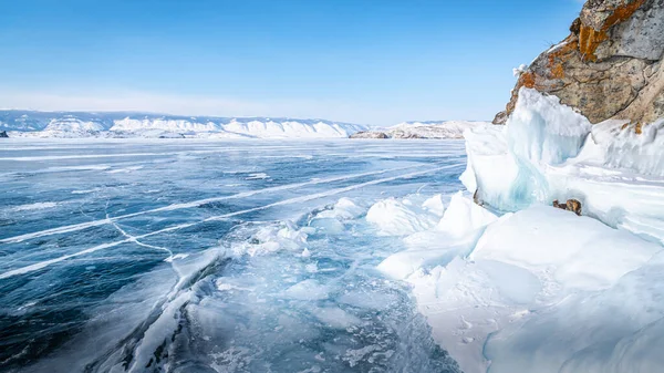 贝加尔湖上的一个岩石岛屿被长长的冰柱环绕 周围是透明的冰 — 图库照片