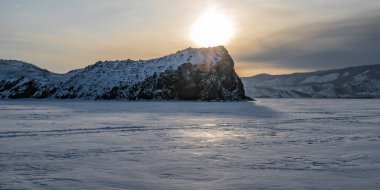 Batan güneşin son ışınları ağaçlık tepelerin arasında Baykal 'ın küçük bir koyunda..